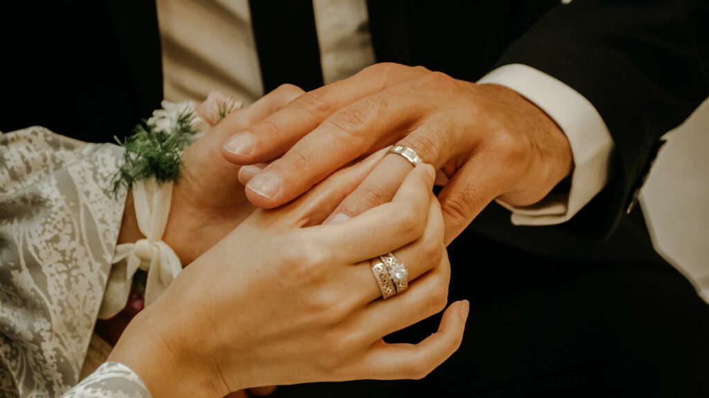 The groom and bride is holding each others hand.