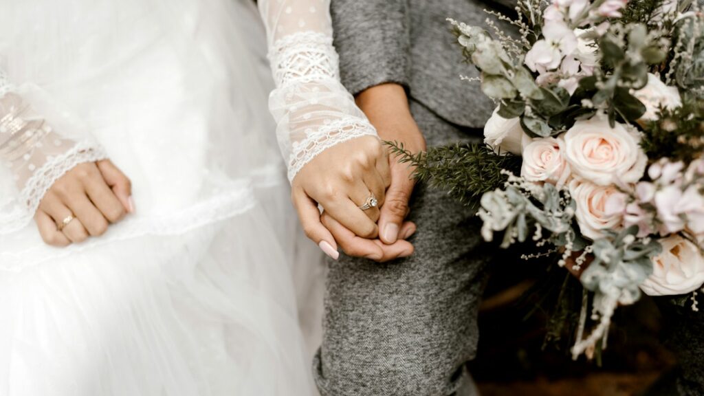 A bride and groom holding hands before wedding ceremony.