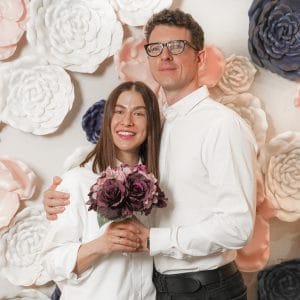 Couple at Wedding against flower wall