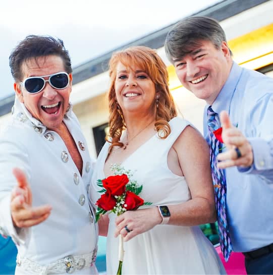 Bride and groom posing for a photo with Elvis Presley impersonator - Elvis-themed weddings