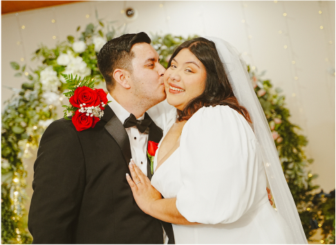 A newly married couple posing in front of camera featuring Imperial Weddings