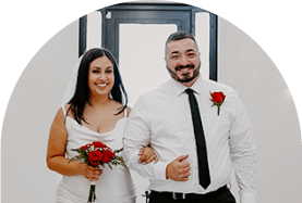 Bride and groom smiling for a photo while walking down the isle