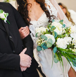 A cropped image of bride and groom with a focus on the bouquet